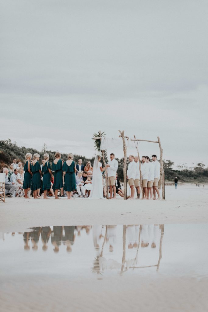 Jasmine and Ben exchanging vows during their ceremony on Clarkes Beach in Byron Bay.